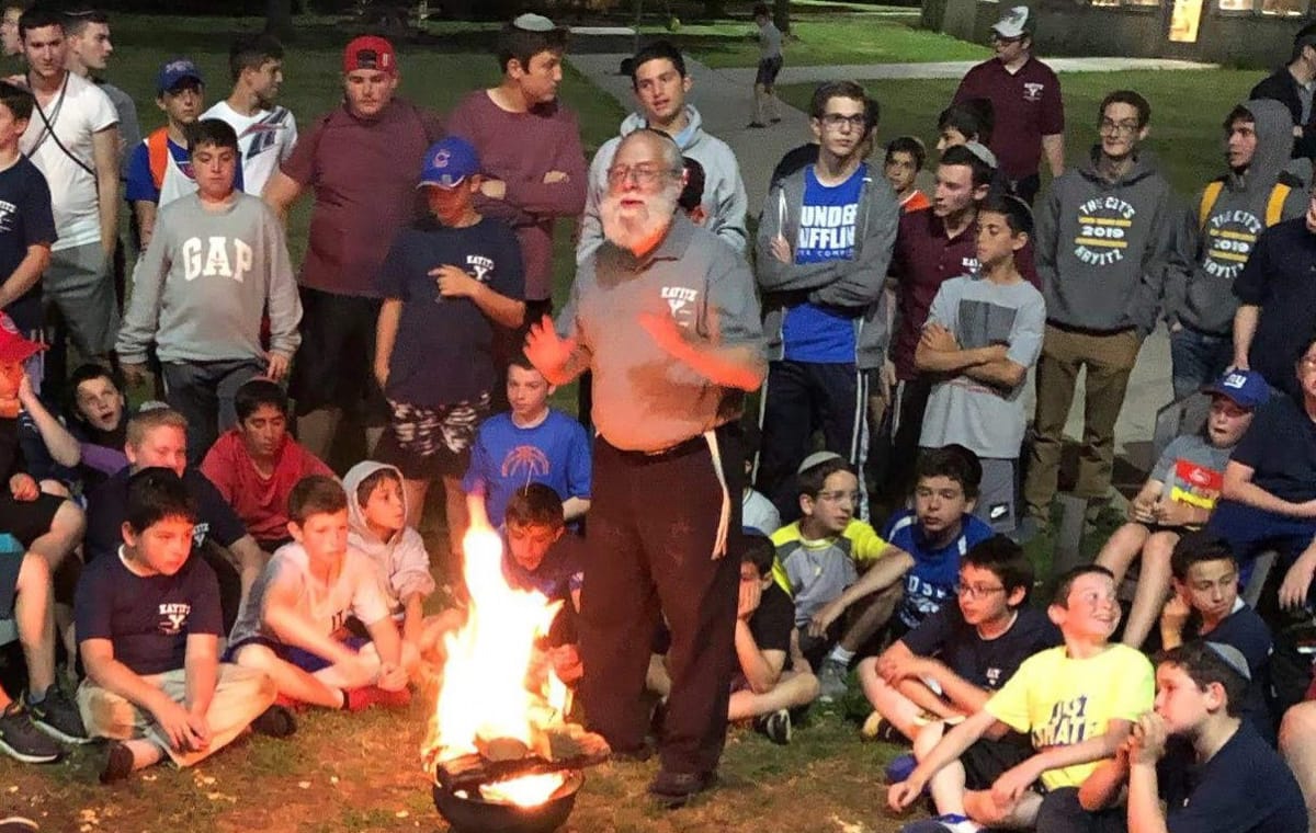 campers and staff around campfire