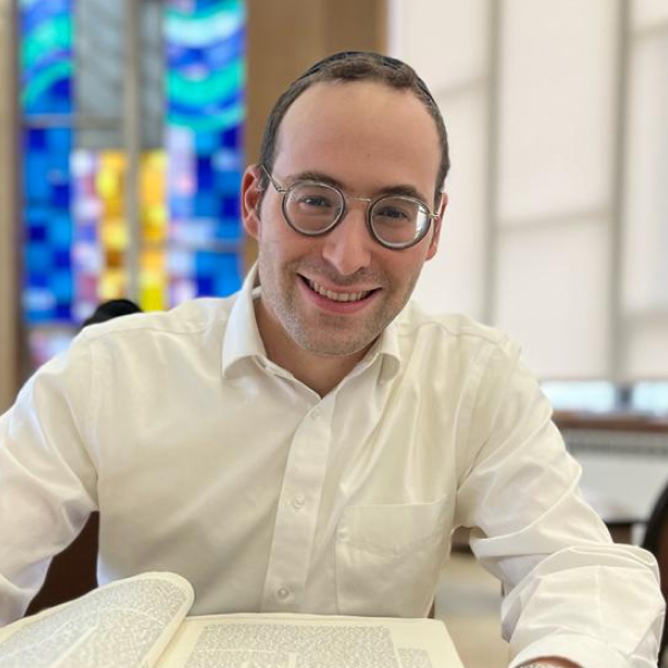 Rabbi Yaakov Rosenberg sitting at table with religious text